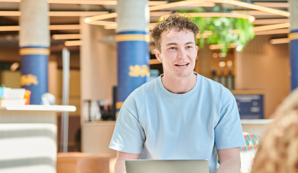 A student working on his laptop in King's Gate