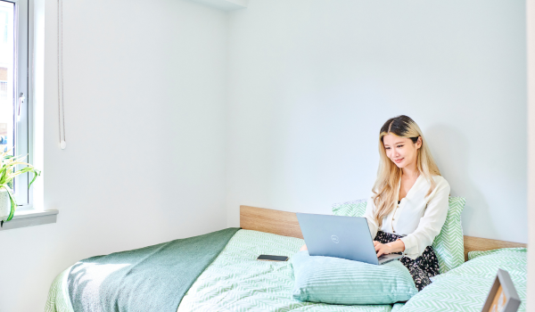 A student working on her laptop in University accomodation