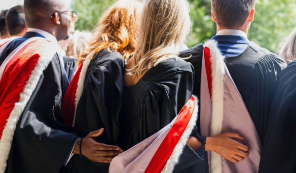 Students graduating - a photograph of the back of a group having their photo taken on campus 