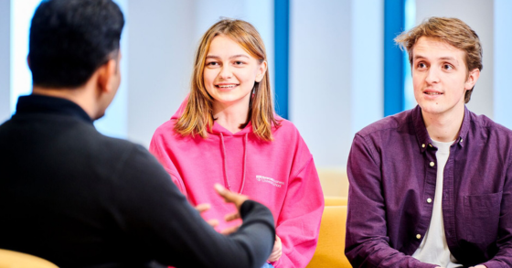 Three students talking and smiling