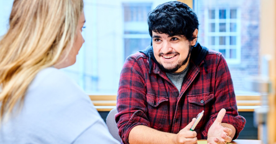 Two students in the Library sharing a laugh