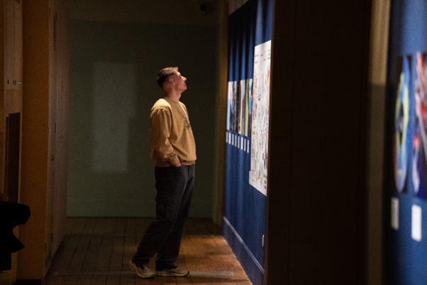 Person looking at images displayed at exhibition