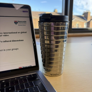 Reusable cup next to laptop