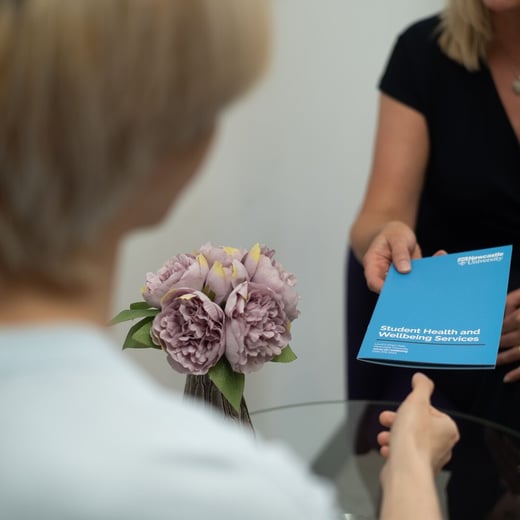 Student Wellbeing leaflet being handed to student