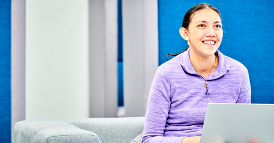 Student smiling at laptop