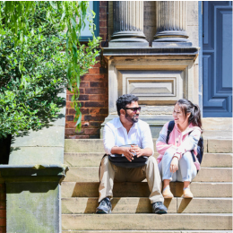 Two students sat on steps - square