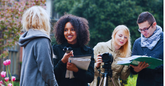 A group of students conducting a video and audio interview on campus