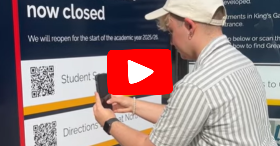 Thumbnail image from video of student scanning a QR codde with a red triangle playhe