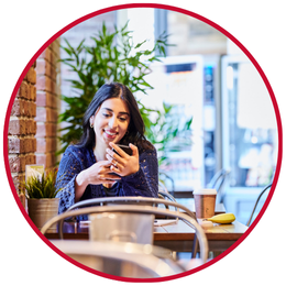 A student checking her phone in a campus café