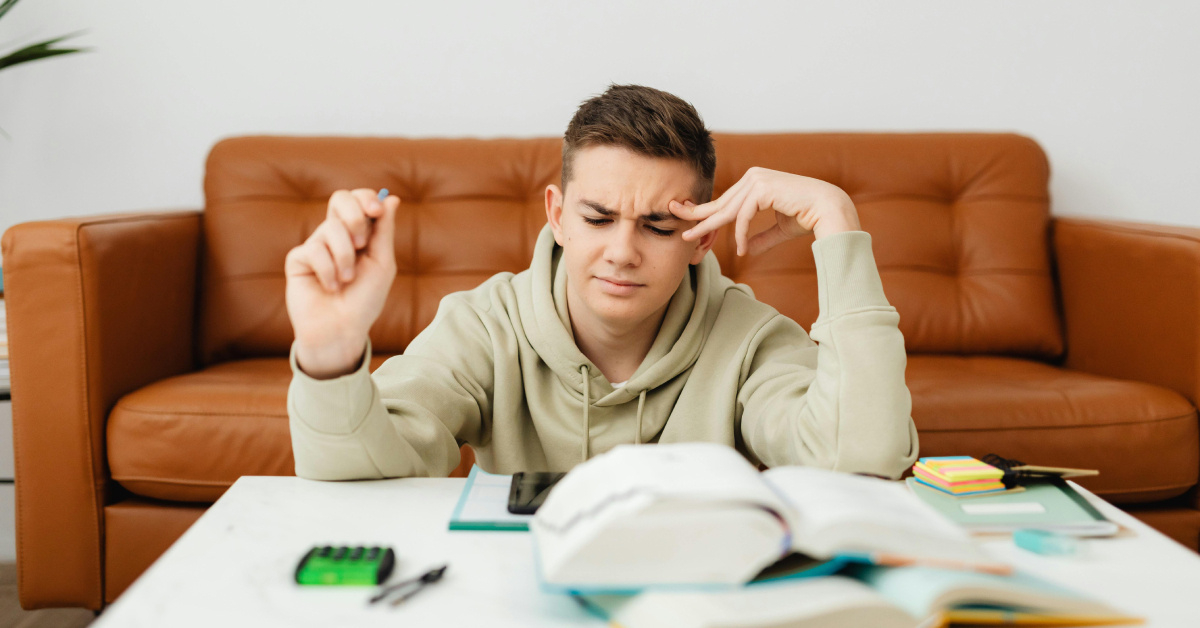 Student looking confused surrounded by books